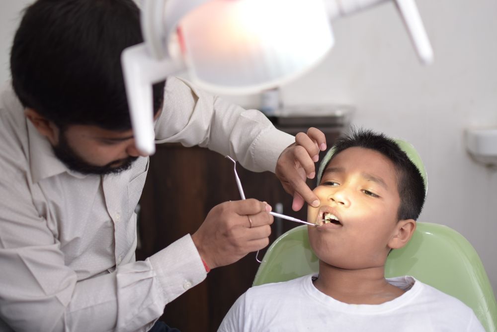 A dentist at the clinic examining a young patient