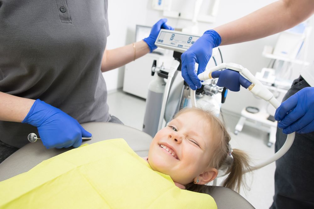 A cheerful child winking during a dental cleaning